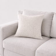Textured pillow on a light gray sofa against a white background
