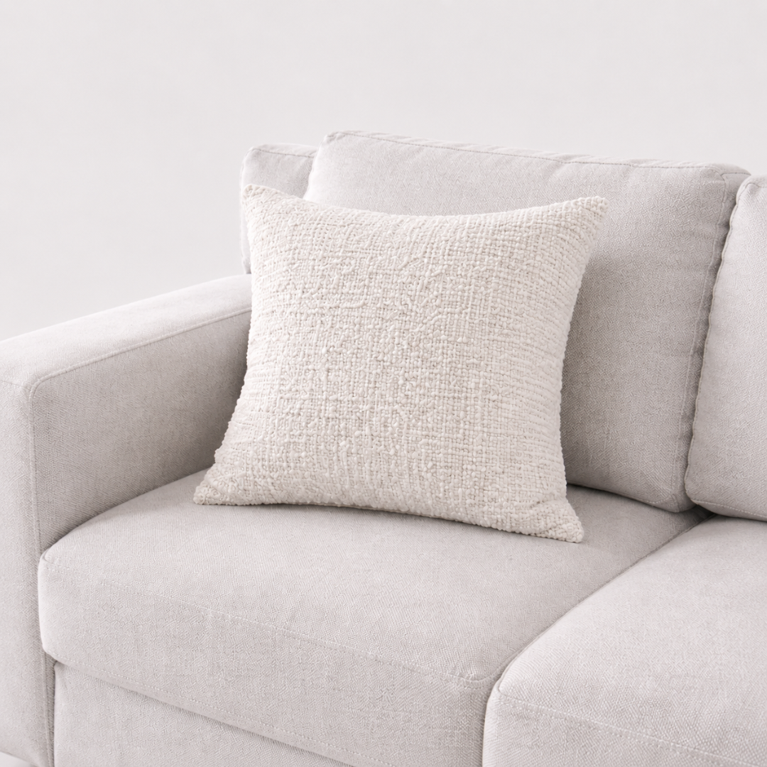 Textured pillow on a light gray sofa against a white background