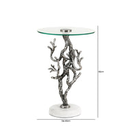 Glass table with silver branch-like base on a white background