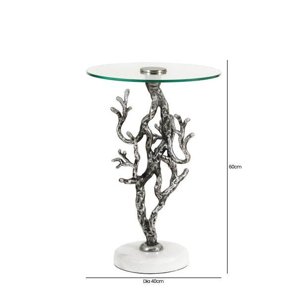 Glass table with silver branch-like base on a white background