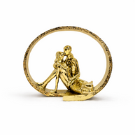 Gold figurine of a couple embracing inside a circular frame on a white background