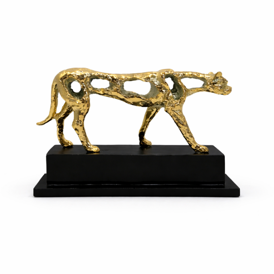 Gold-finish abstract panther sculpture with an openwork design on a black base, styled on a modern entryway console.