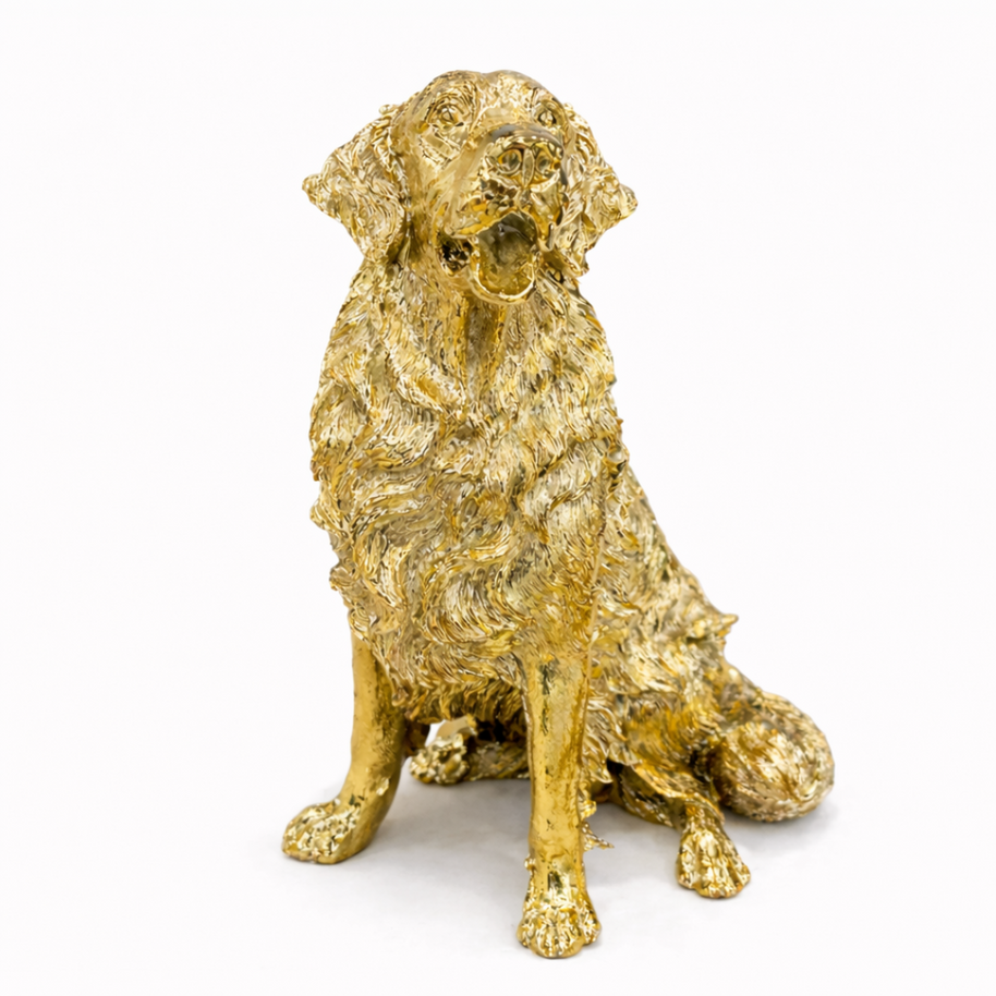 Antique gold-finish Golden Retriever dog sculpture with textured fur, displayed on a modern wooden sideboard.