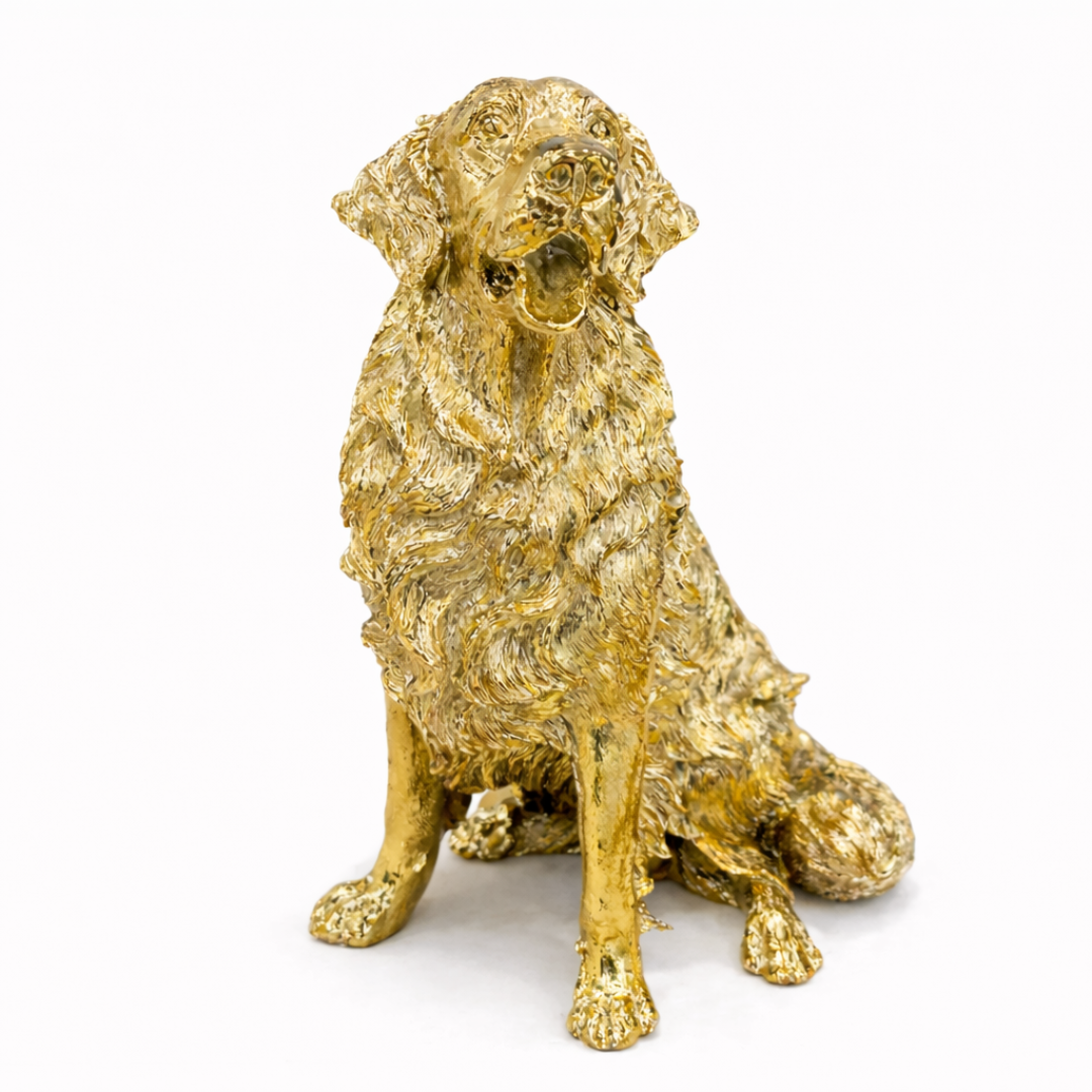 Antique gold-finish Golden Retriever dog sculpture with textured fur, displayed on a modern wooden sideboard.