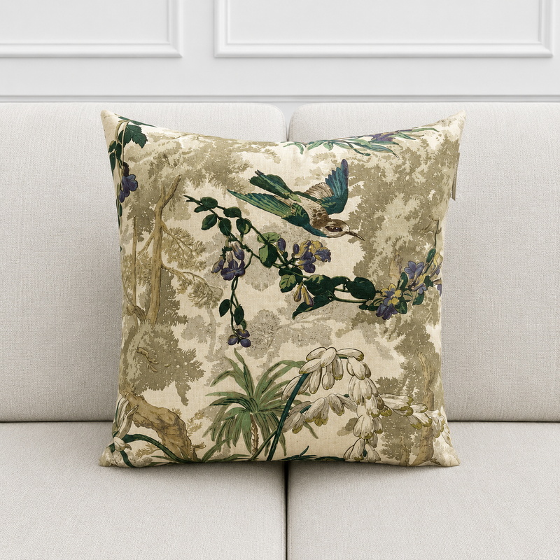 Decorative pillow with floral and bird pattern on a beige sofa.