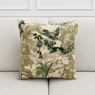 Decorative pillow with floral and bird pattern on a beige sofa.