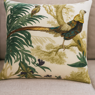 Decorative pillow with bird and leaf pattern on a beige couch