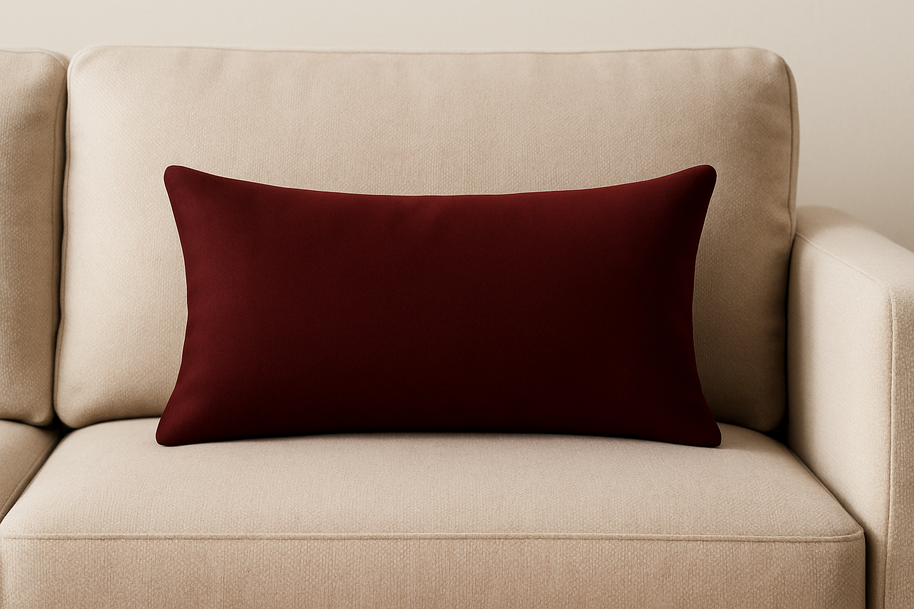 Beige sofa with a mulberry velvet cushion on a plain background