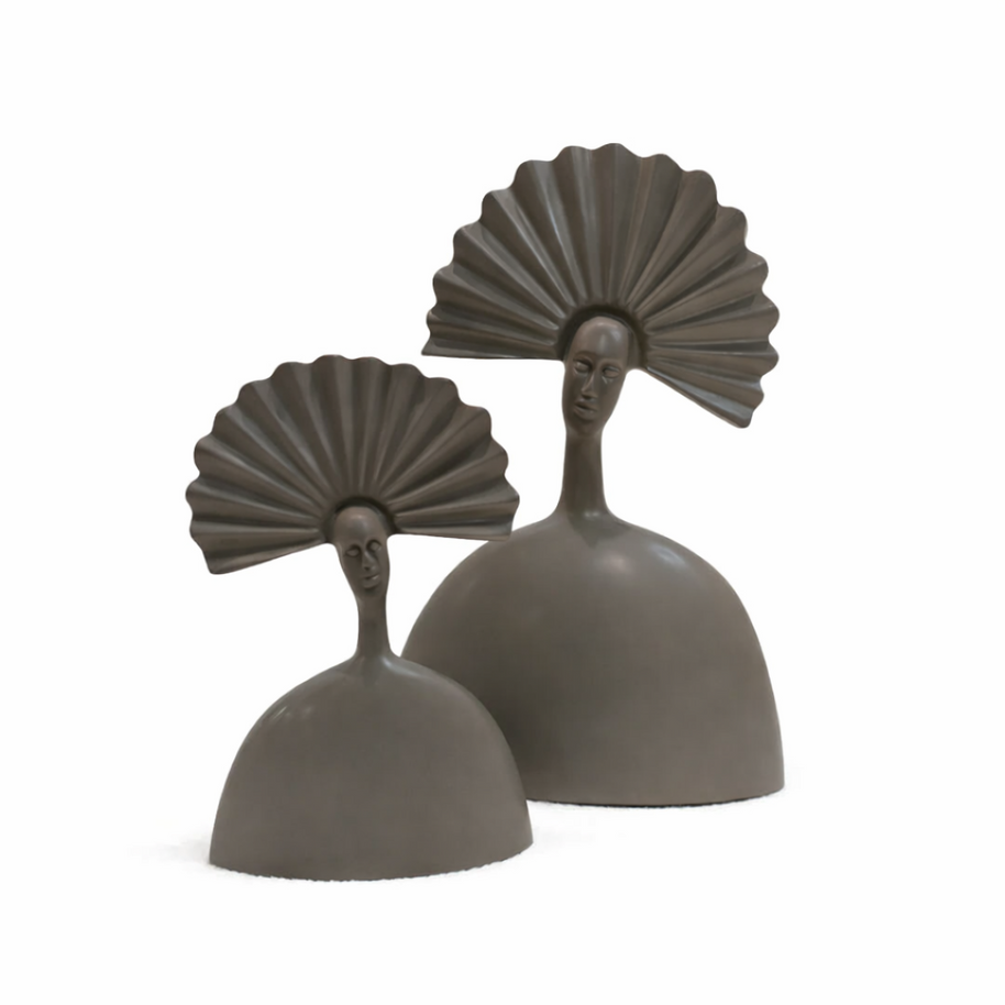 Pair of modern taupe sculptural figures with fan-shaped headdresses on a light oak console table.