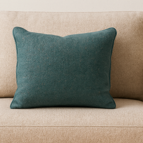 Beige sofa with a teal cushion on a neutral background