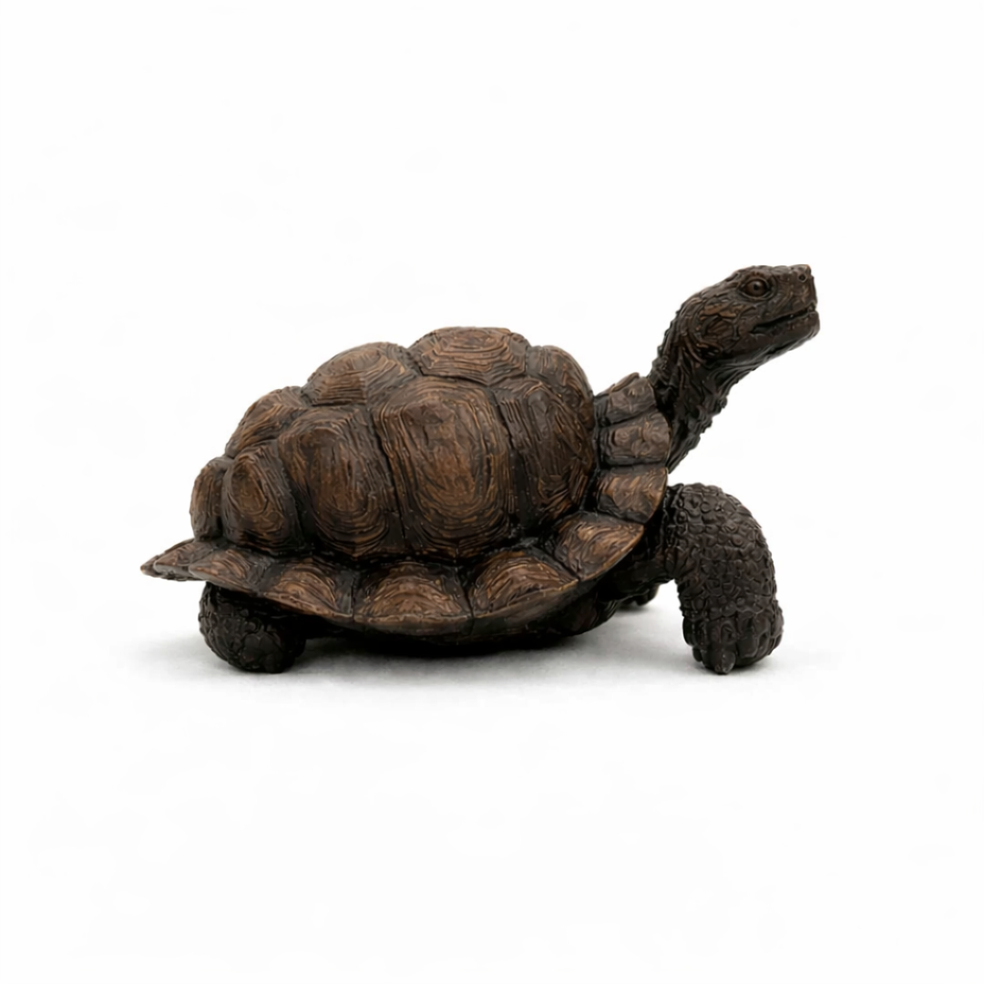 Realistic tortoise ornament with a textured brown shell displayed on a rustic wooden shelf next to a potted plant.