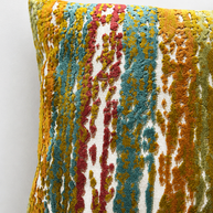 Multicolored textured pillow on a light gray background