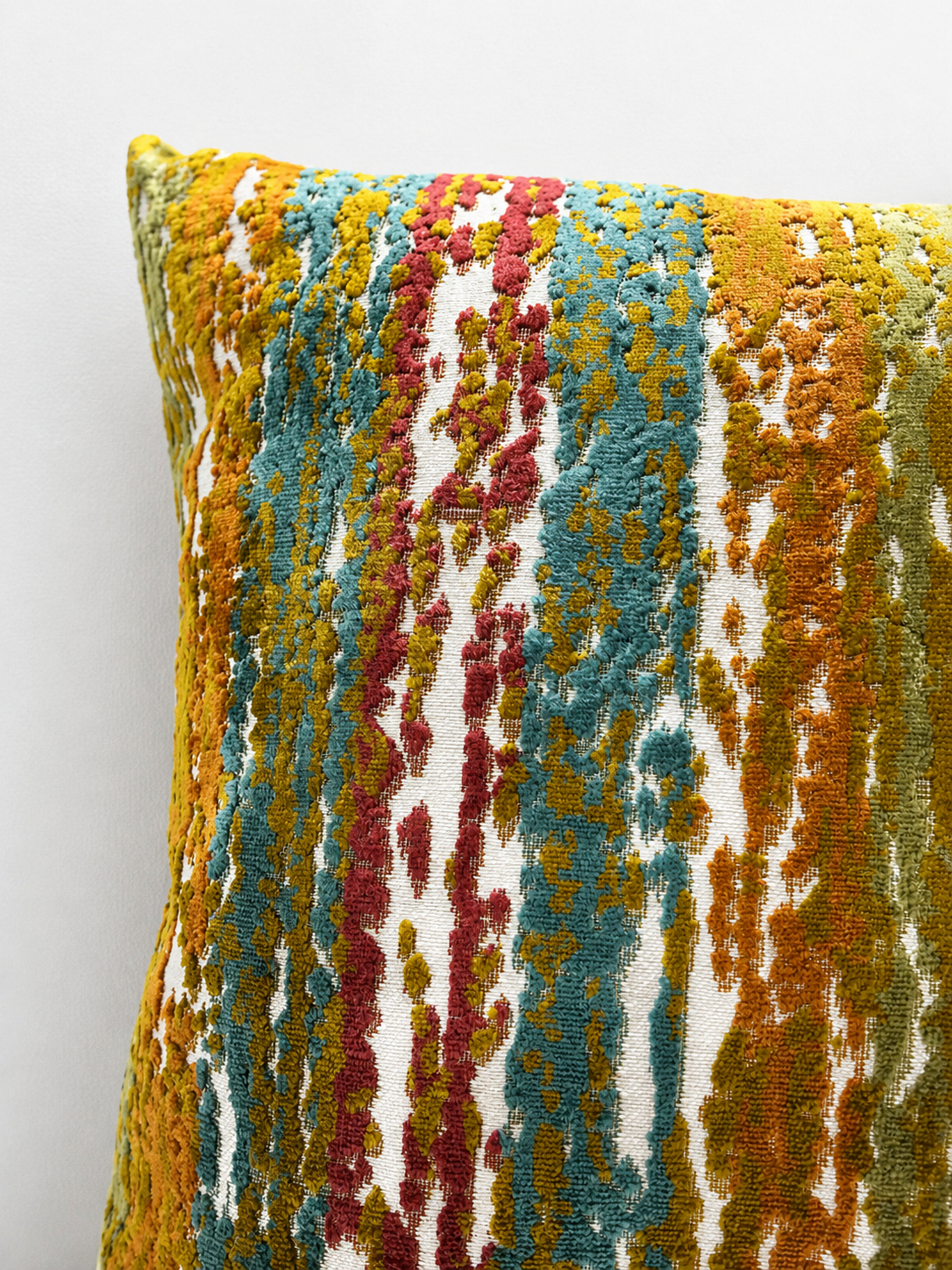 Multicolored textured pillow on a light gray background