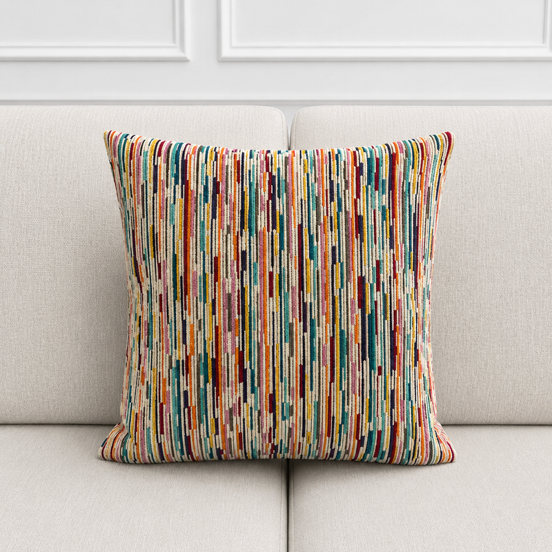 Colorful striped pillow on a light gray sofa with a white wall background