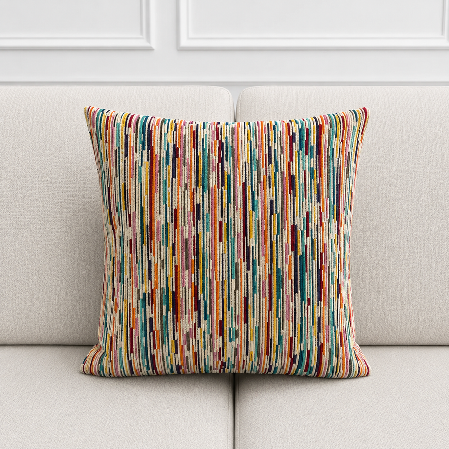 Colorful striped pillow on a light gray sofa with a white wall background