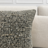 Textured throw pillow on a beige sofa with a neutral background