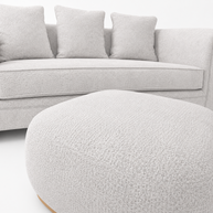 Gray sofa with cushions and a matching ottoman on a white background