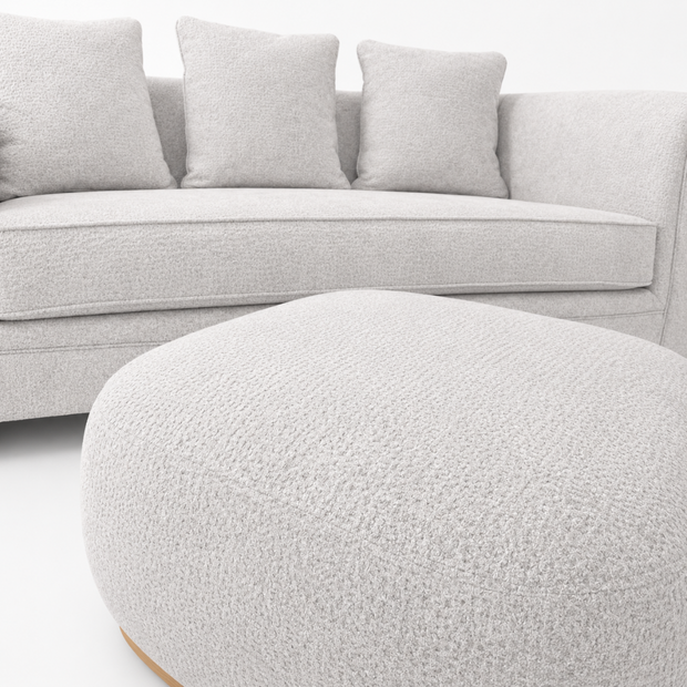 Gray sofa with cushions and a matching ottoman on a white background