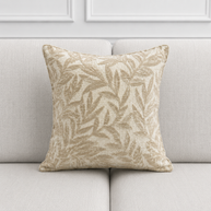 Decorative pillow with leaf pattern on a light gray sofa