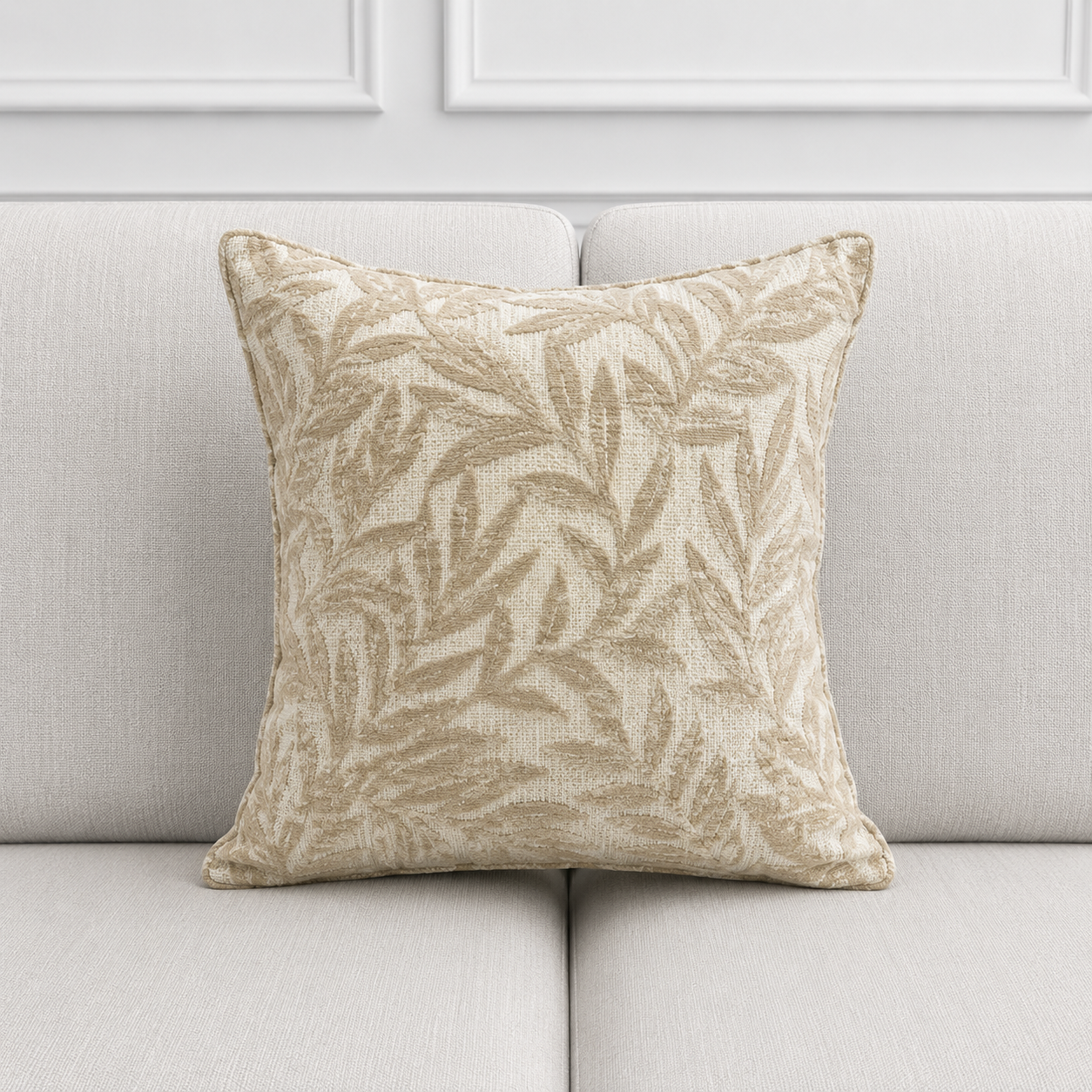 Decorative pillow with leaf pattern on a light gray sofa